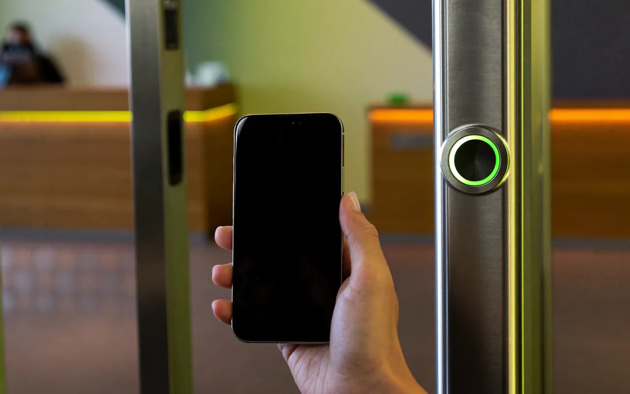 Cliente che avvicina il telefono al lettore QR all’ingresso di una palestra
